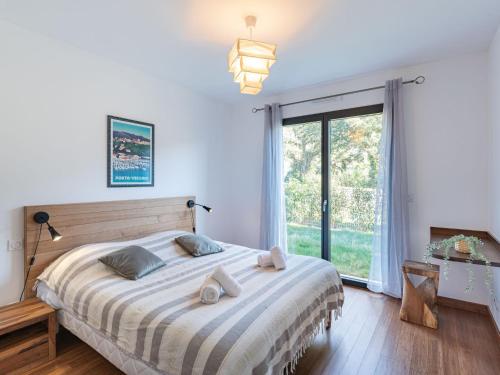 une chambre avec un grand lit et une grande fenêtre dans l'établissement Apartment Domaine d'Arca-3 by Interhome, à Porto-Vecchio