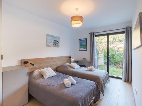 deux lits dans une chambre avec une fenêtre dans l'établissement Apartment Domaine d'Arca-3 by Interhome, à Porto-Vecchio