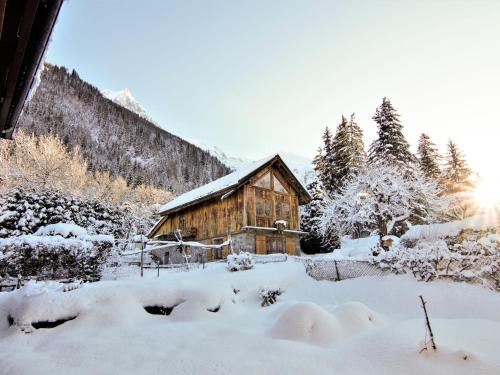 une cabane en bois recouverte de neige devant les arbres dans l'établissement Apartment Maison Maffioli by Interhome, à Chamonix-Mont-Blanc