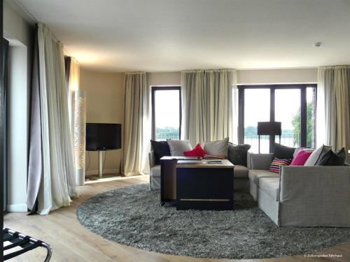 a living room with a couch and a table at Zollenspieker Fährhaus in Hamburg