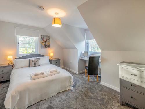 a bedroom with a large white bed and a desk at Holiday Home Loch Ness House by Interhome in Drumnadrochit