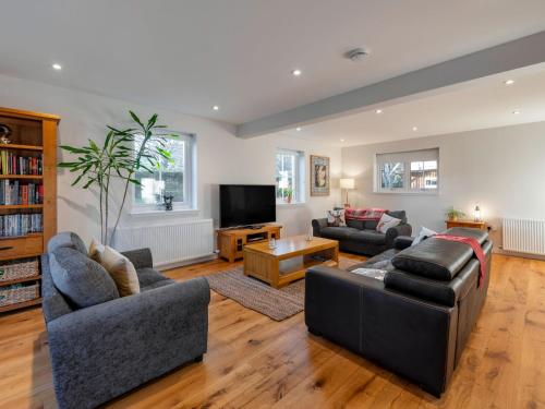 a living room with two couches and a tv at Holiday Home Loch Ness House by Interhome in Drumnadrochit