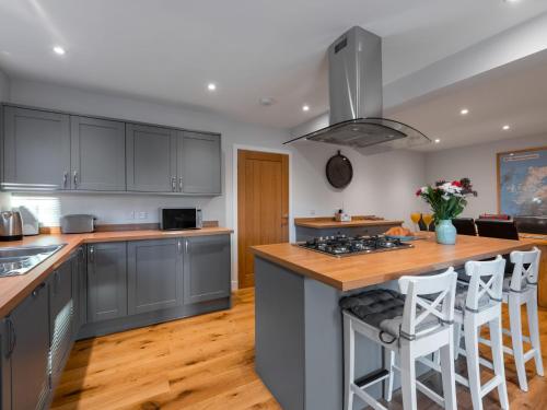 a kitchen with gray cabinets and a island with bar stools at Holiday Home Loch Ness House by Interhome in Drumnadrochit