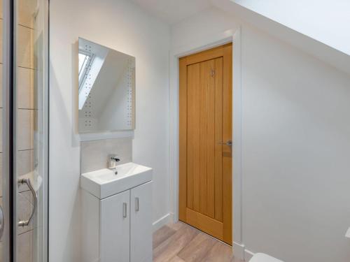 a bathroom with a sink and a wooden door at Holiday Home Loch Ness House by Interhome in Drumnadrochit