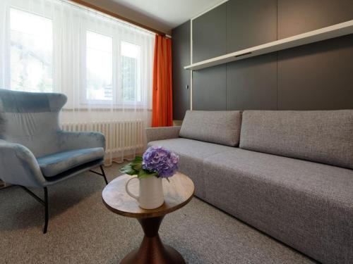 ein Wohnzimmer mit einem Sofa, einem Stuhl und einem Tisch in der Unterkunft Apartment Hubertus-1 by Interhome in Zermatt