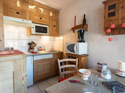 une cuisine avec des placards en bois et une table avec une chaise dans l'établissement Apartment Bel Alp 23 by Interhome, à Saint-Gervais-les-Bains