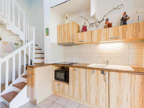 a kitchen with wooden cabinets and a sink at Apartment Les Jardins du Nil by Interhome in Cap d'Agde