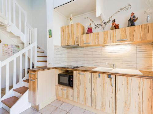 une cuisine avec des armoires en bois et un évier dans l'établissement Apartment Les Jardins du Nil by Interhome, au Cap d'Agde