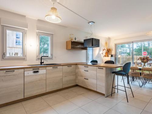 une cuisine avec des armoires en bois et une table et des chaises dans l'établissement Holiday Home Dune Blanche-1 by Interhome, à Seignosse