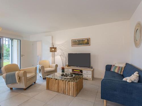 un salon avec un canapé bleu et une télévision dans l'établissement Holiday Home Dune Blanche-1 by Interhome, à Seignosse