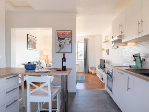 une cuisine avec des placards blancs et une table avec des tabourets blancs dans l'établissement Apartment Errepira by Interhome, à Guéthary