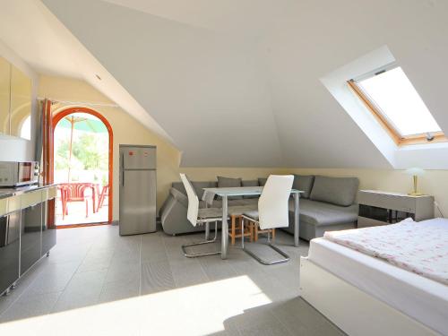 een keuken en woonkamer met een tafel en een bank bij Holiday Home Elisabeta Grande by Interhome in Balatonőszöd