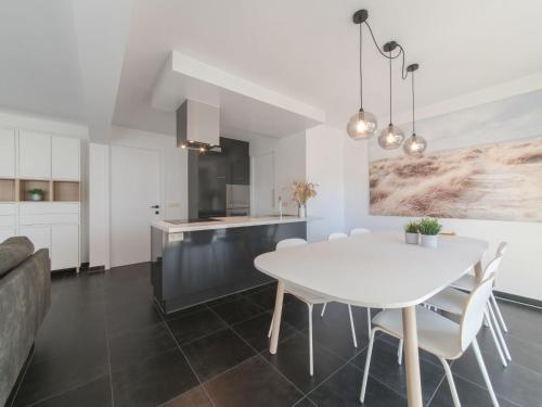 cocina y comedor con mesa blanca y sillas en Apartment Miramar by Interhome, en Ostende