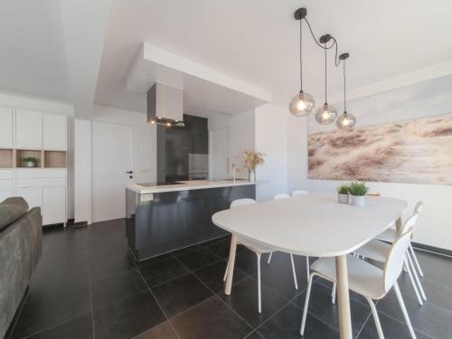 kuchnia i jadalnia z białym stołem i krzesłami w obiekcie Apartment Miramar by Interhome w Ostendzie