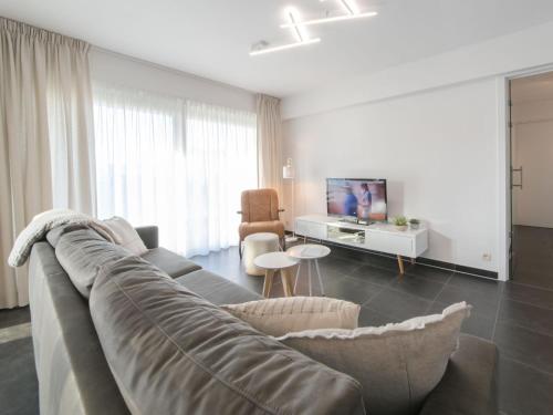 a living room with a couch and a tv at Apartment Miramar by Interhome in Ostend