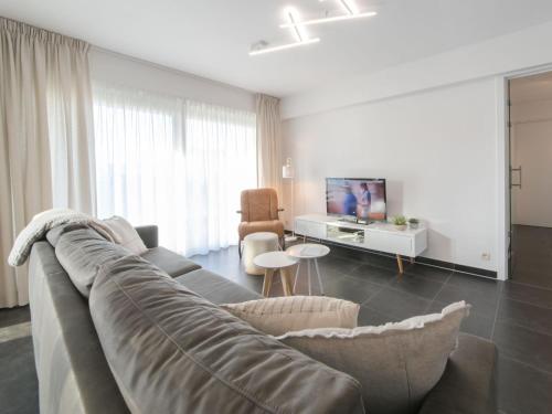 salon z kanapą i telewizorem w obiekcie Apartment Miramar by Interhome w Ostendzie