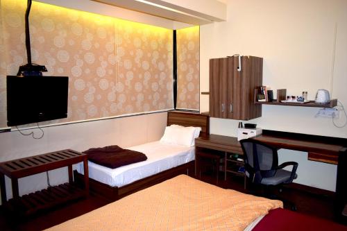 a bedroom with a desk and a bed and a desk at Apartment In Mumbai City Centre in Mumbai