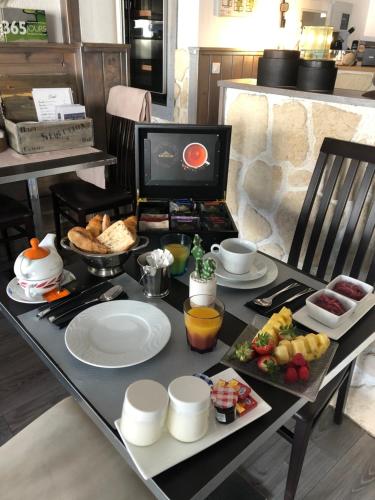un tavolo con un vassoio di prodotti per la colazione di Hôtel Restaurant de Londres a Saint-Just-en-Chevalet