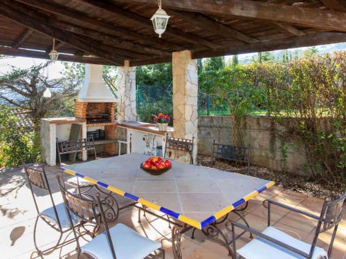 una mesa y sillas en un patio con fogones en Holiday Home El Suro by Interhome, en Calonge