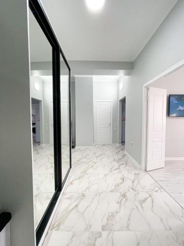 an empty living room with marble flooring and a large mirror at ЖК Баспана in Atyraū