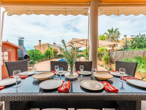 a table with red napkins and glasses on a patio at Holiday Home Francaset by Interhome in Roda de Bará