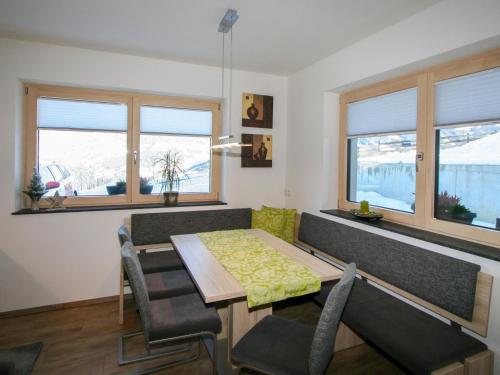 a dining room with a table and chairs and windows at Apartment Kirchler by Interhome in Hippach