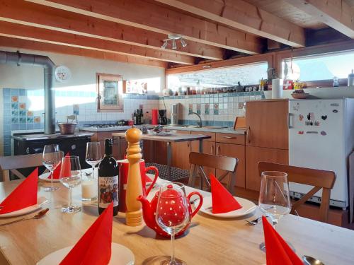 una mesa de comedor con servilletas rojas y copas de vino en Holiday Home Rustico Bel Panorama by Interhome en Malvaglia