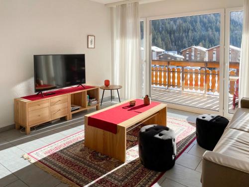 a living room with a flat screen tv and a couch at Apartment Golf C by Interhome in Leukerbad