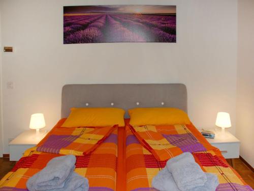 1 dormitorio con 1 cama con 2 toallas y 2 lámparas en Apartment Antica Scuderia by Interhome en Muralto