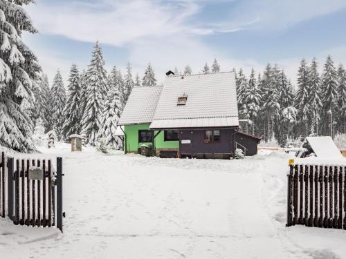 a house covered in snow with trees in the background at Holiday Home Jelení kout by Interhome in Smržovka