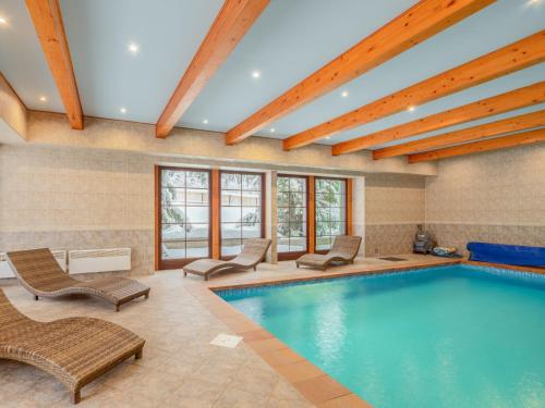 a pool in a hotel room with chairs and a swimming pool at Holiday Home Jelení kout by Interhome in Smržovka