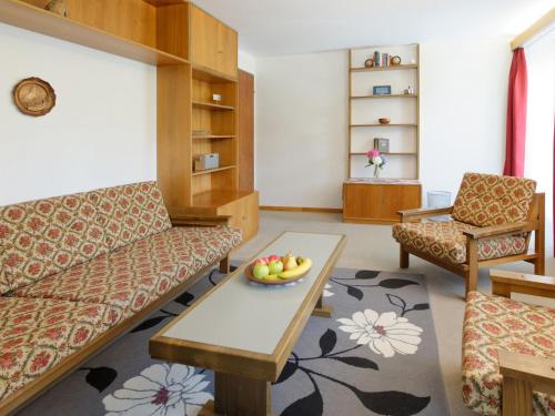 - un salon avec un canapé et une corbeille de fruits sur une table dans l'établissement Apartment Hubertus-2 by Interhome, à Zermatt