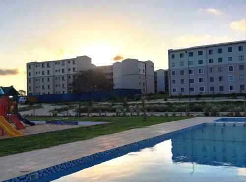 a swimming pool in a park with two buildings at Kiki's @ Palm Ridge-Vipingo in Kilifi
