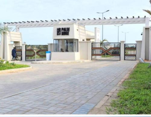 a building with a gate and a person standing in front at Kiki's @ Palm Ridge-Vipingo in Kilifi