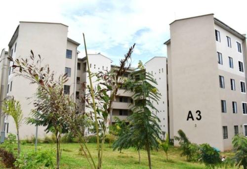 two white apartment buildings with trees in the foreground at Kiki's @ Palm Ridge-Vipingo in Kilifi