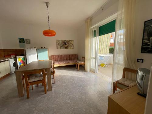 a kitchen and living room with a table and a couch at casa comoda a due passi dal mare in Il Monte