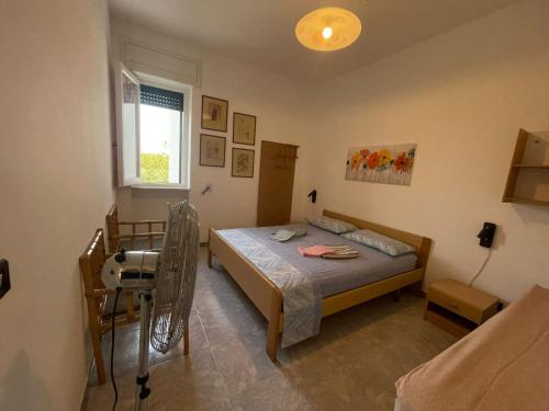a bedroom with a bed and a chair and a window at casa comoda a due passi dal mare in Il Monte