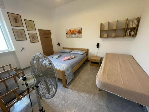 a bedroom with a bed and a fan in it at casa comoda a due passi dal mare in Il Monte