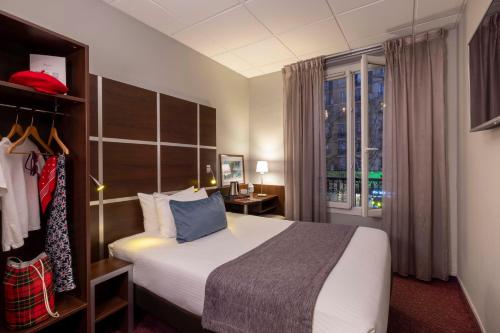 パリにあるHôtel L'Interludeのベッドと窓が備わるホテルルーム