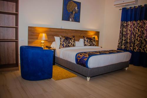 a bedroom with a king sized bed with a blue headboard at BLUEBAY HOTEL ABIDJAN in Abidjan