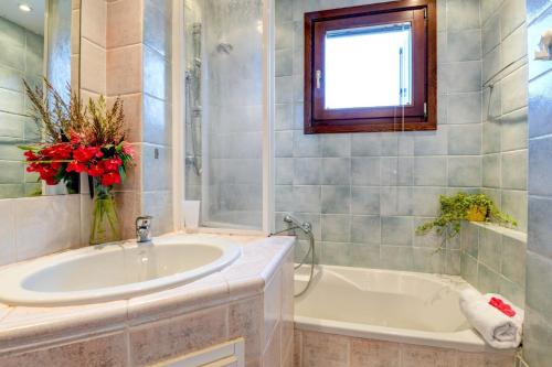 een badkamer met een wastafel, een bad en een raam bij Villa Rosa in Manerba del Garda