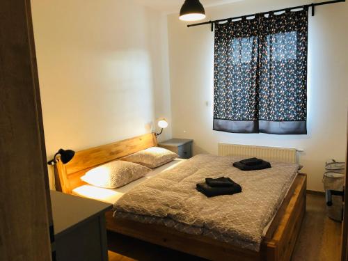 a bedroom with a bed with two black shoes on it at Apartmán Kašperky in Kašperské Hory