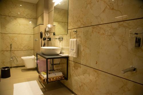 uma casa de banho com um lavatório e um WC em GOLDEN PARK HOTEL & RESORT em Māldah