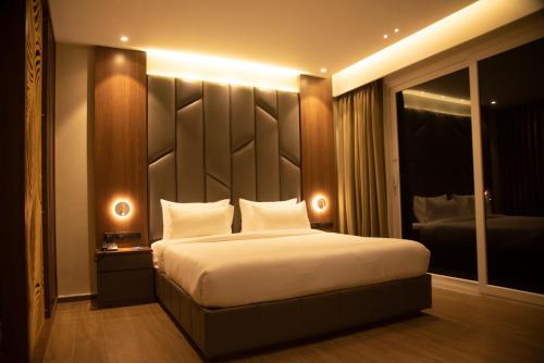 um quarto com uma cama grande e uma grande cabeceira. em GOLDEN PARK HOTEL & RESORT em Māldah