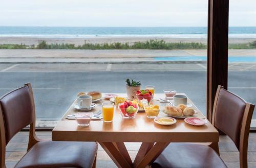 a table with breakfast food and a view of the ocean at Hotel Campanario Del Mar in La Serena