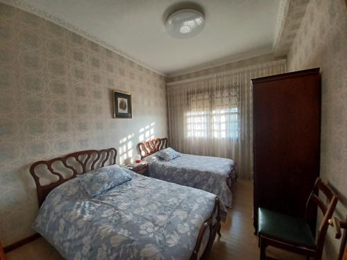 Baralla的住宿－Caserío Félix，一间卧室配有两张床和椅子
