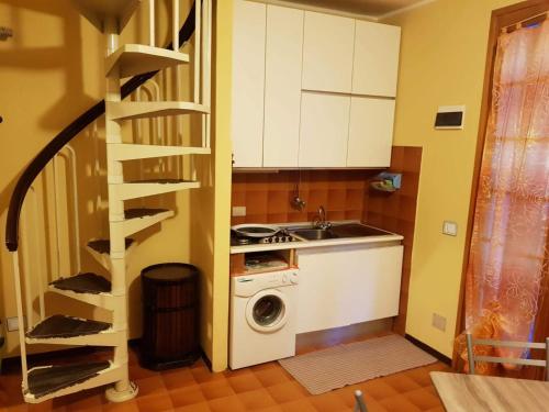 eine Küche mit einer Waschmaschine und einer Wendeltreppe in der Unterkunft Appartamento vista mare Lido Scacchi in Lido di Scacchi