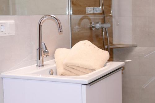 un lavabo blanco con una toalla. en Ferienhaus Weißpriach, en Weisspriach