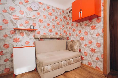 a small kitchen with a chair and flowers on the wall at Квартира в центре города in Sumy