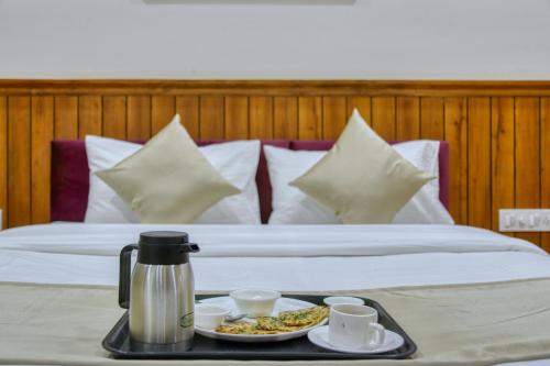 un letto con un vassoio di cibo su un tavolo di Hotel Centre Park Bhopal a Bhopal